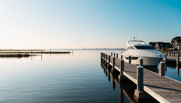 Wit motorjacht aan een houten steiger in een Nederlandse jachthaven